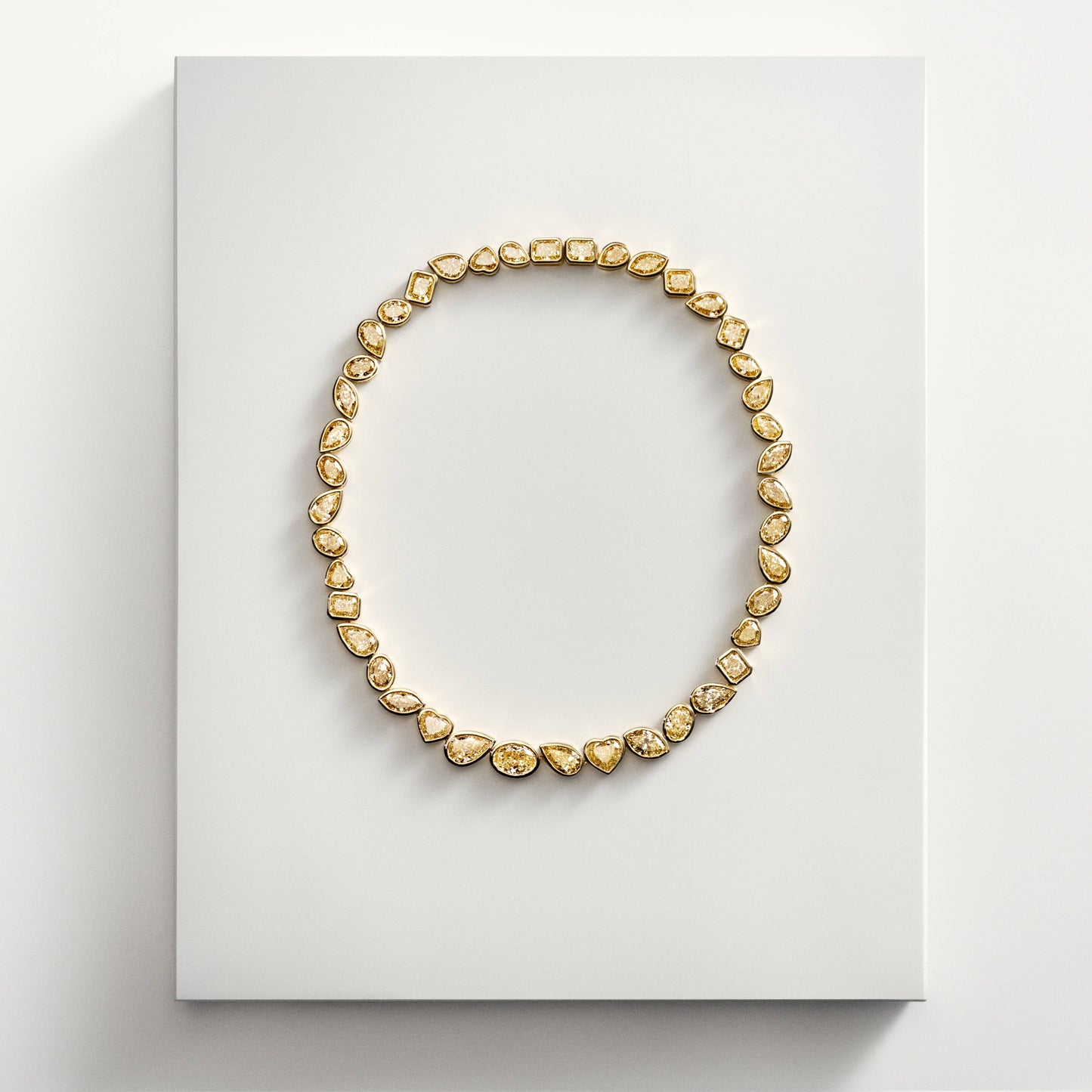 Gold necklace with mixed shape yellow diamonds on display
