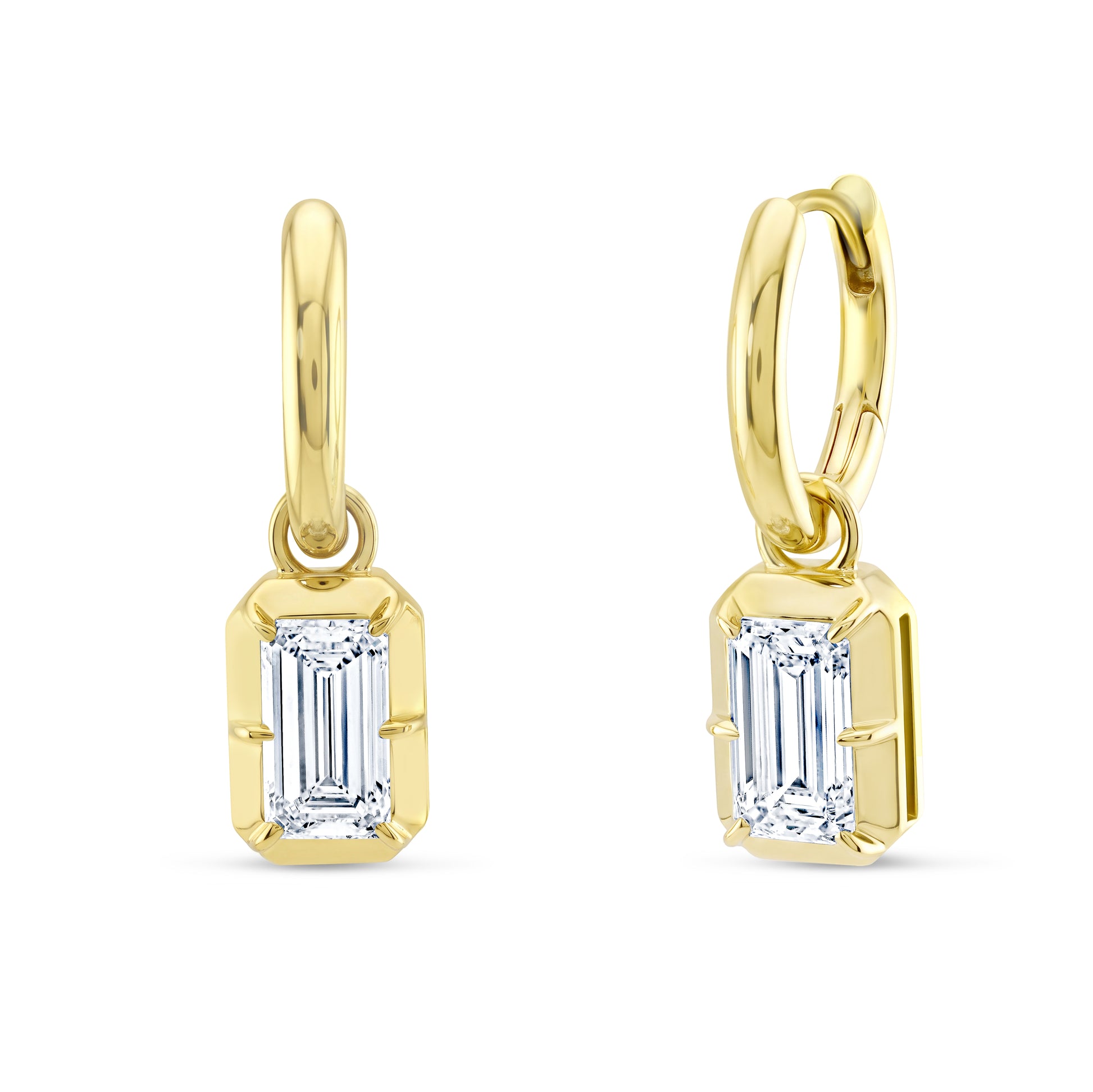 A pair of gold huggie hoop earrings with white emerald cut diamonds, shown on a plain white background.
