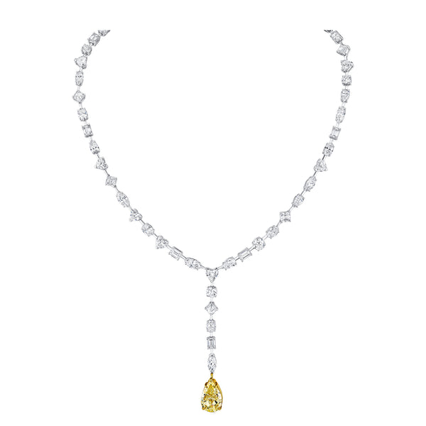 A lariat necklace featuring multiple clear diamonds along the chain and a large fancy yellow pear diamond drop.
