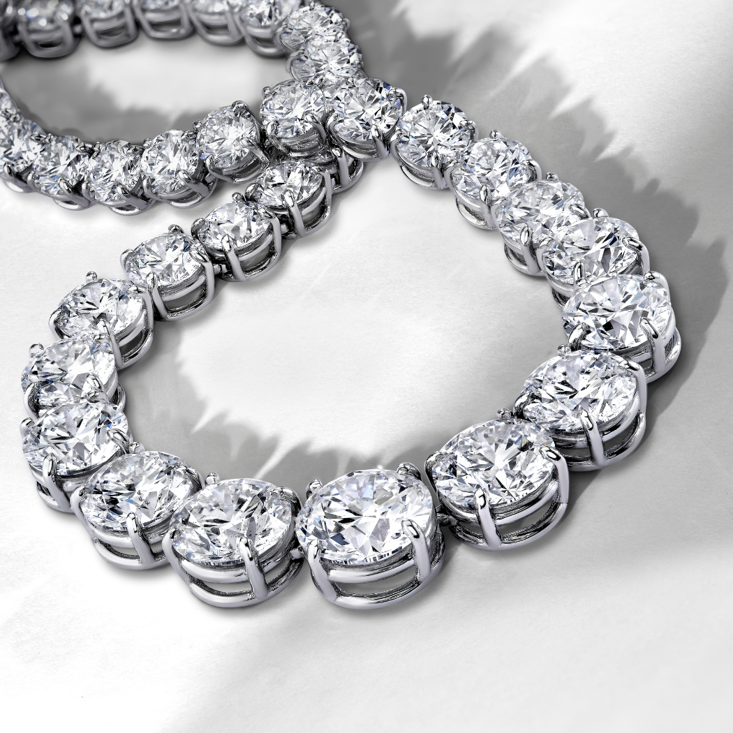 Close-up of a diamond tennis bracelet on a reflective surface