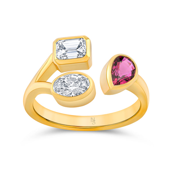 Gold ring with two mixed shaped diamonds and a ruby gemstone on a white background