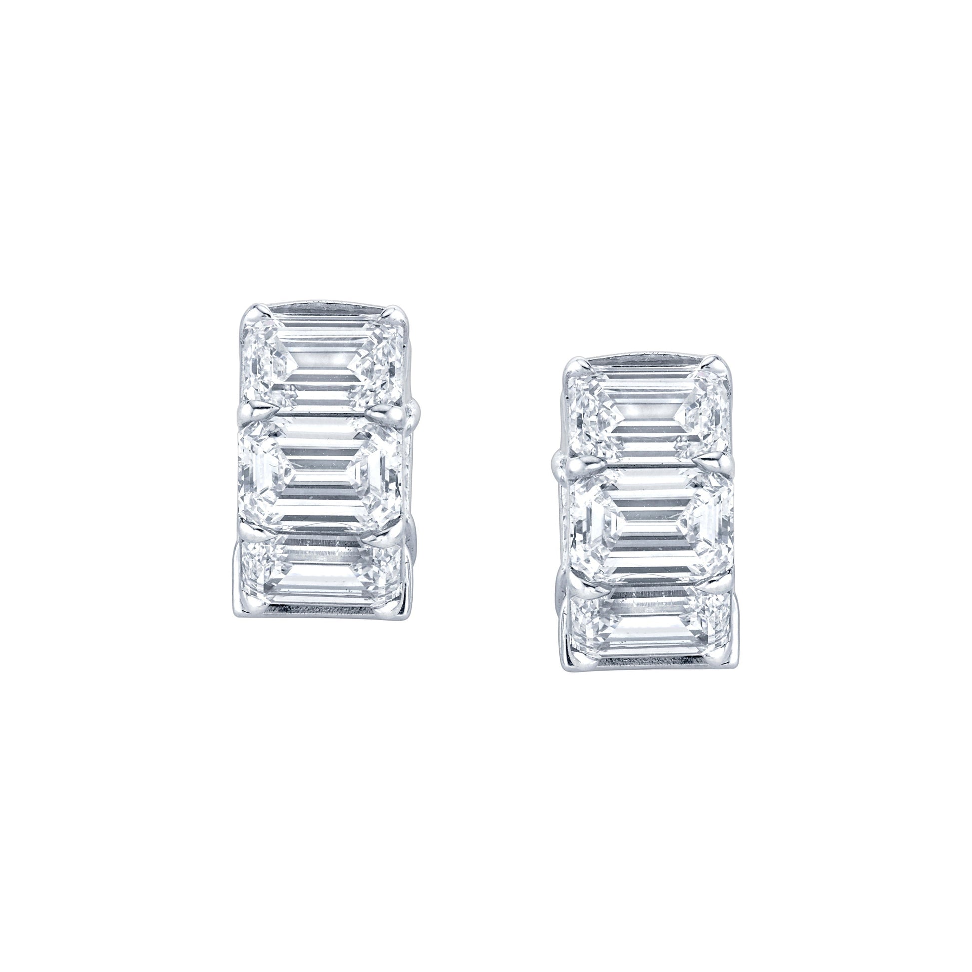 A pair of emerald cut diamond huggie earrings in 18k white gold.