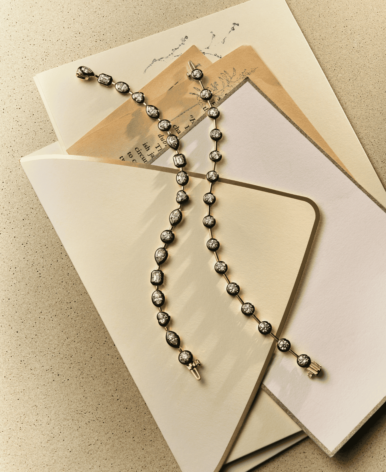 18k gold bracelets with bezel set diamonds held in place by rhodium on a textured surface