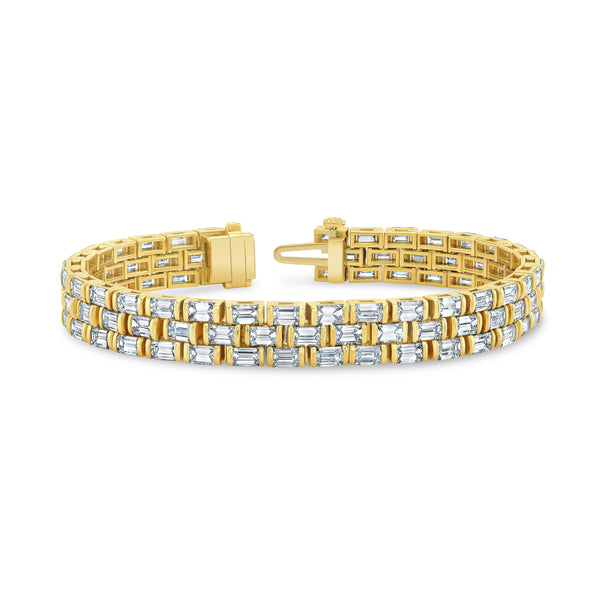 A yellow gold watch band featuring a series of emerald-cut diamonds set in a channel-style bracelet.