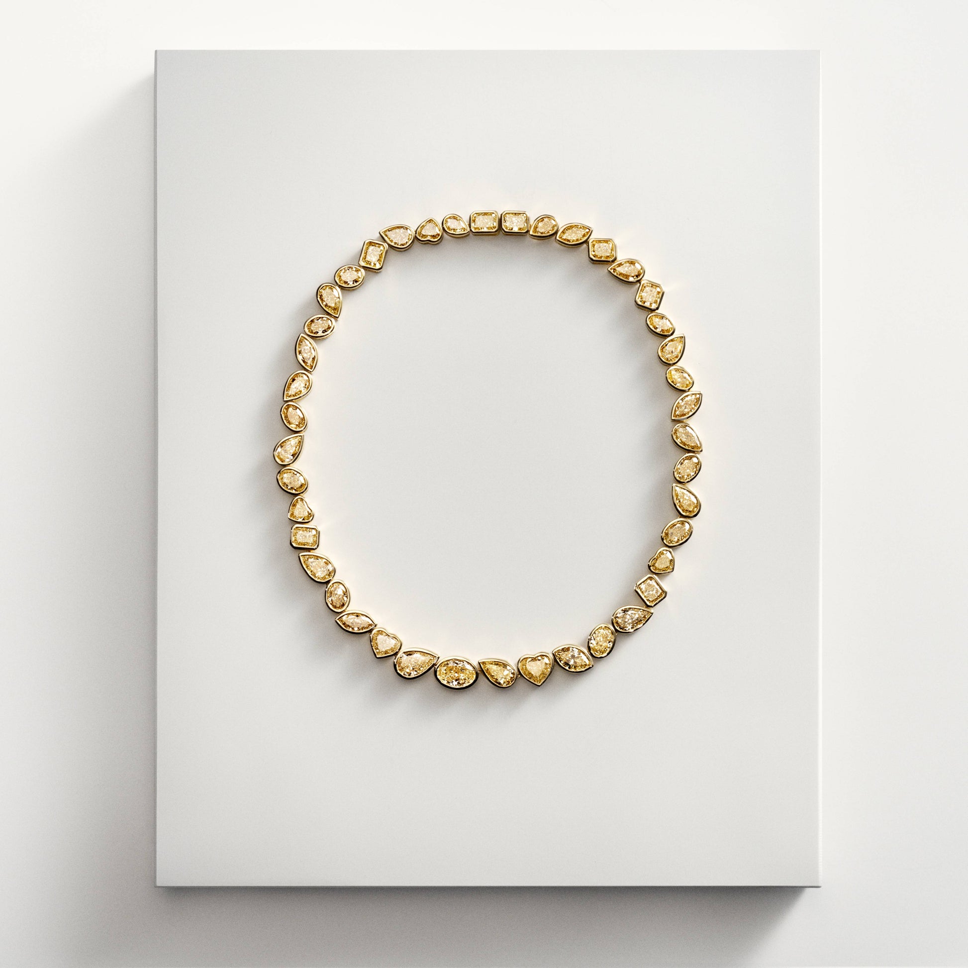 Gold necklace with mixed shape yellow diamonds on display