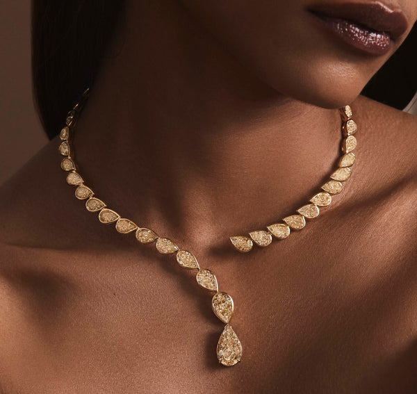 Gold chocker necklace with fancy yellow pear shaped diamonds worn and resting on the neck.