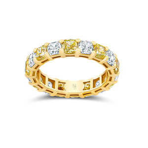 Gold eternity band with alternating yellow and white diamonds on a white background
