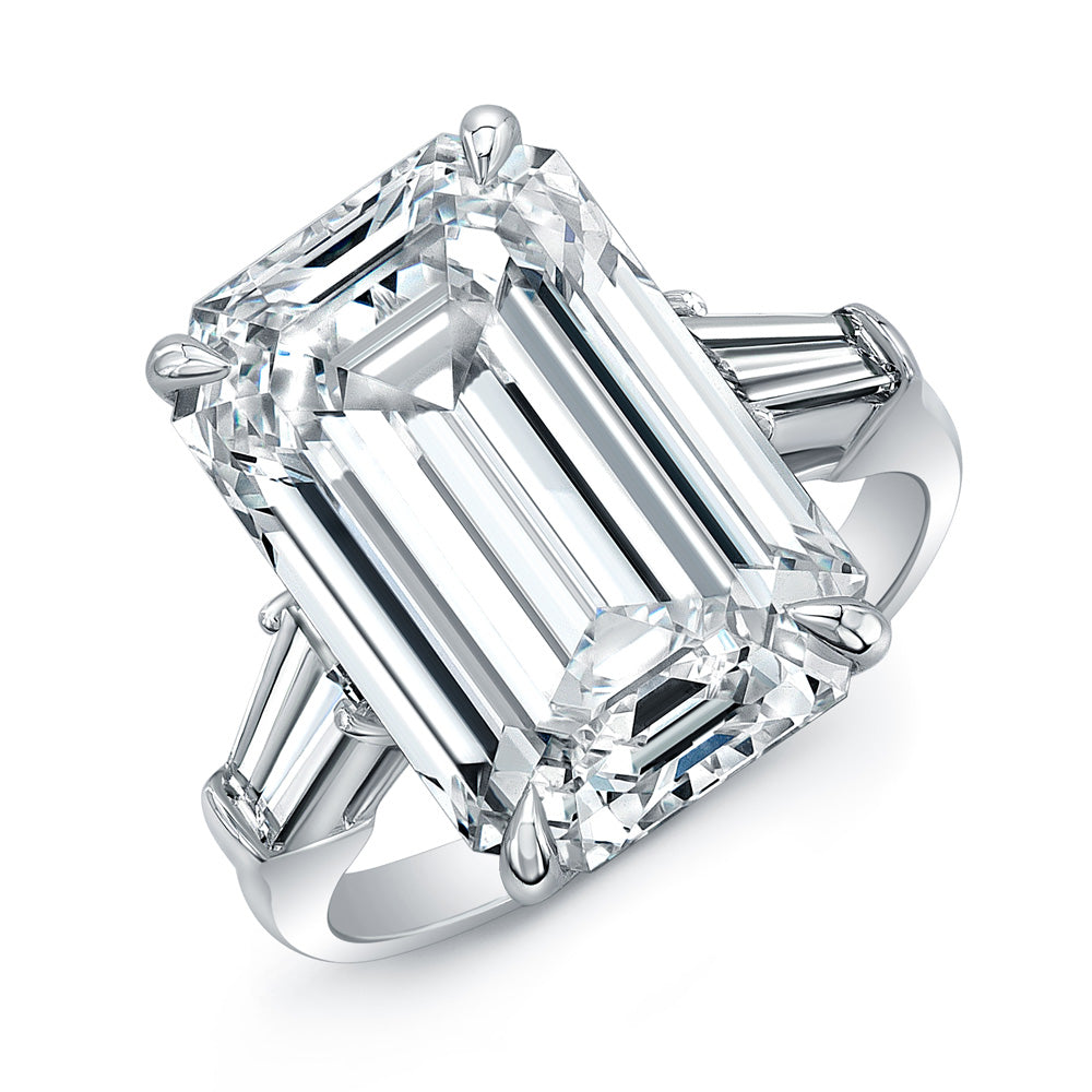 An emerald cut diamond ring with tapered baguette side stones set in platinum.