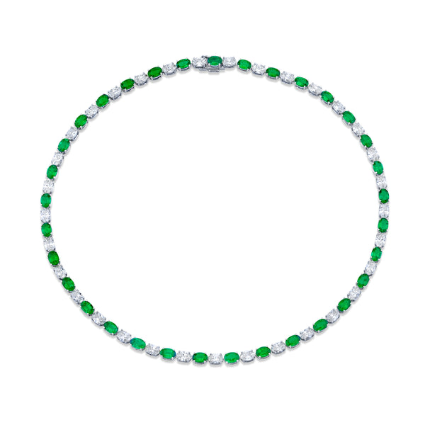 A necklace featuring a series of oval-cut diamonds and green emeralds, set in a white gold setting.