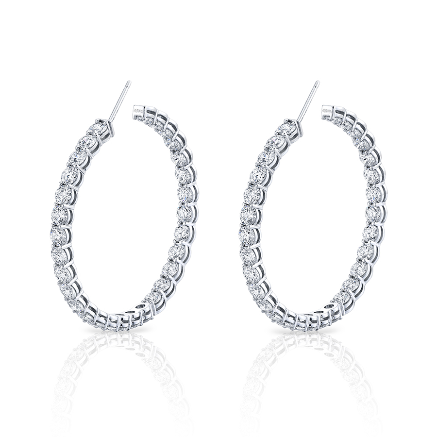 A pair of large round diamond hoop earrings crafted in 18k white gold, featuring diamonds set on the inside and outside of the hoops.