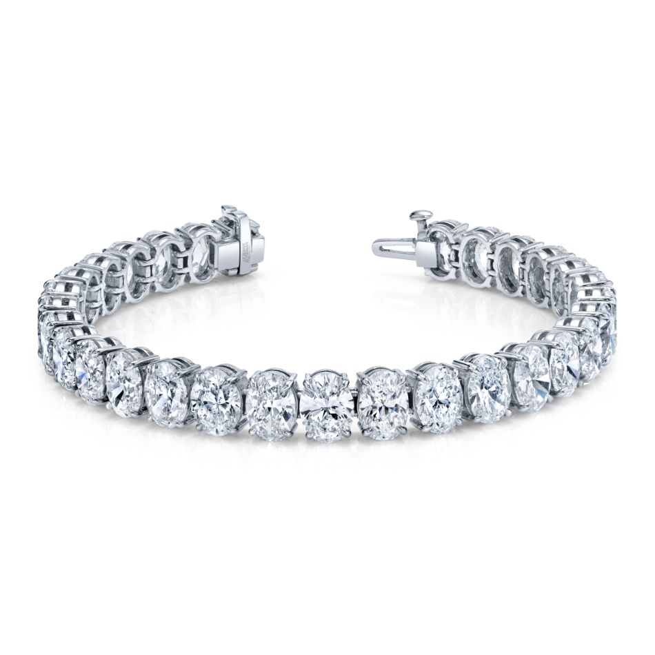 A platinum bracelet featuring a row of oval and round diamonds set in a straight line.